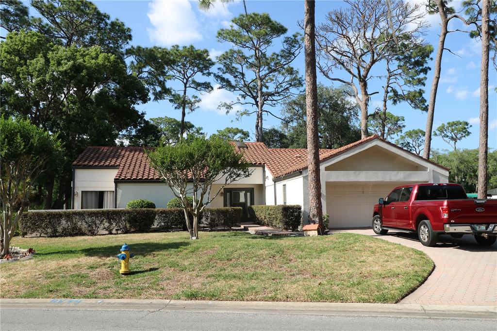 A single-story house with a red tile roof, white stucco walls, and a red pickup truck — 5424 SADDLEBROOK WAY, WESLEY CHAPEL, FL
