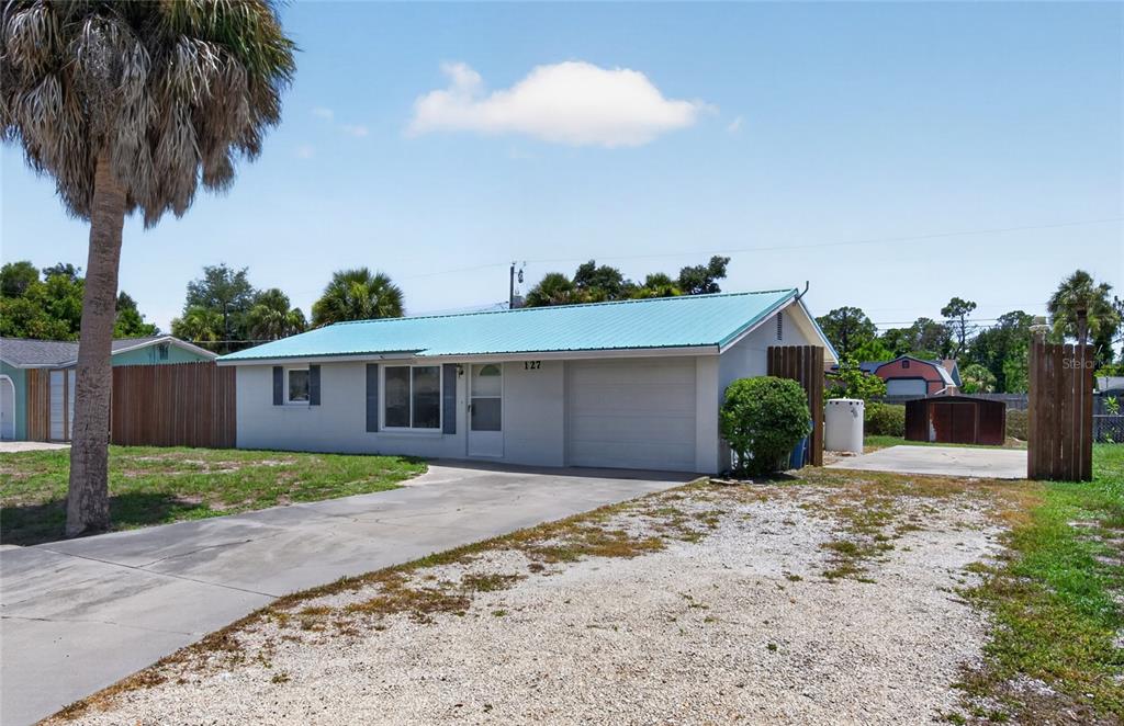 A single-story house with a light blue metal roof and a concrete driveway — 127 COLUMBIA ROAD, VENICE, FL