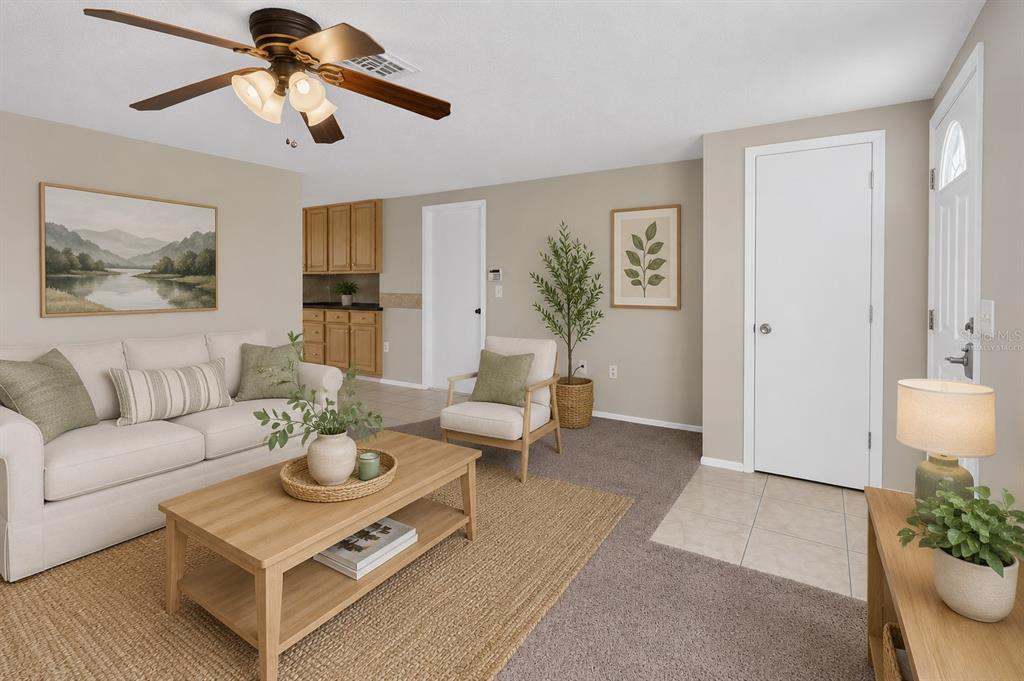 A living room with a beige sofa, wooden coffee table, armchair, and a ceiling fan — 127 COLUMBIA ROAD, VENICE, FL