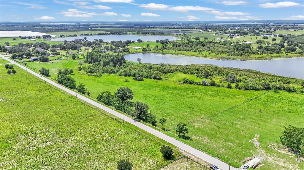 An aerial view shows a rural landscape with a road, green fields, and two lakes — 8450 ALTURAS BABSON PARK CUTOFF ROAD, BARTOW, FL