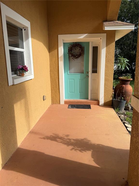 A covered porch features a teal front door, a window with flowers, and a large planter — 1131 DOGWOOD AVENUE, TAMPA, FL