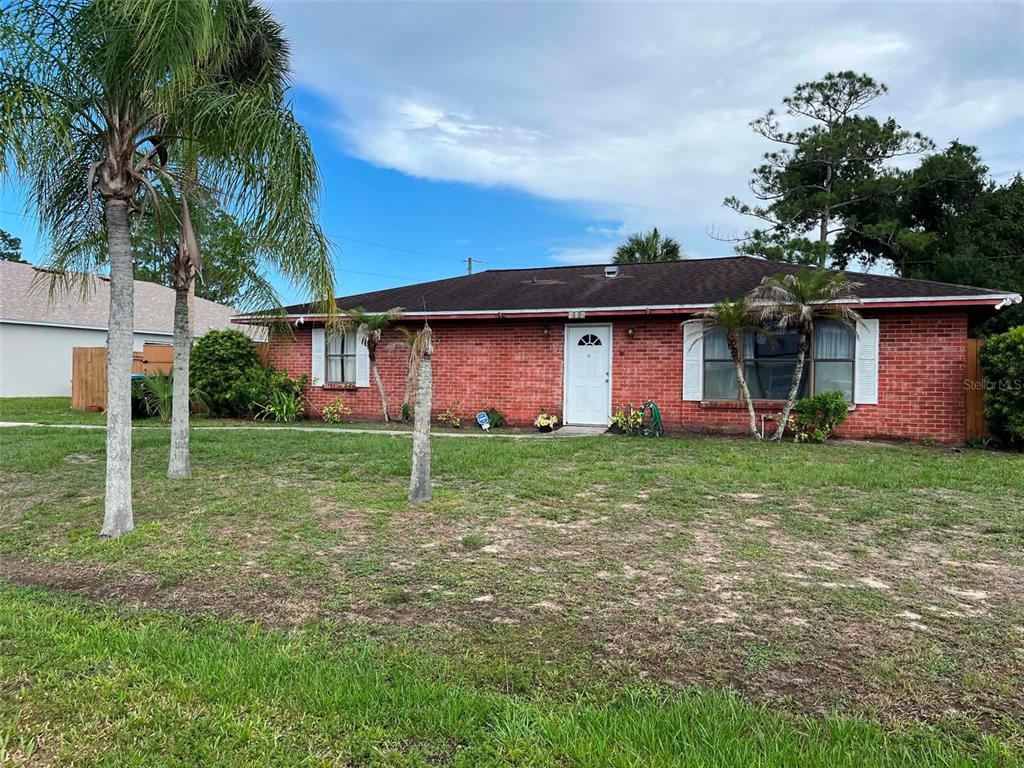 A single-story red brick house with a dark roof and a front lawn — 688 AIROSO ROAD SE, PALM BAY, FL