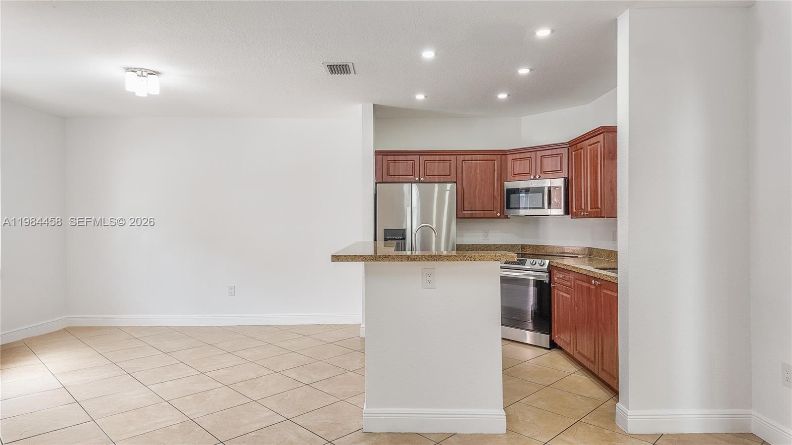 A kitchen features wood cabinets, stainless steel appliances, and a granite-topped breakfast bar — 6002 SW 8th St # 3, West Miami FL 33144, WEST MIAMI, FL