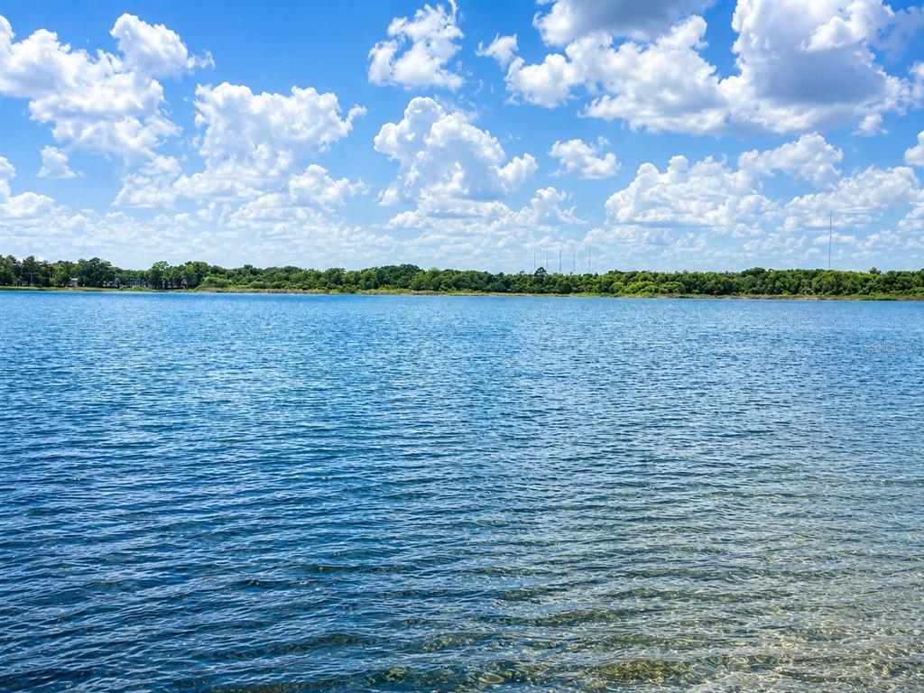 A view of a calm lake under a bright blue sky with scattered white clouds — 632 MAYS COURT, ORLANDO, FL