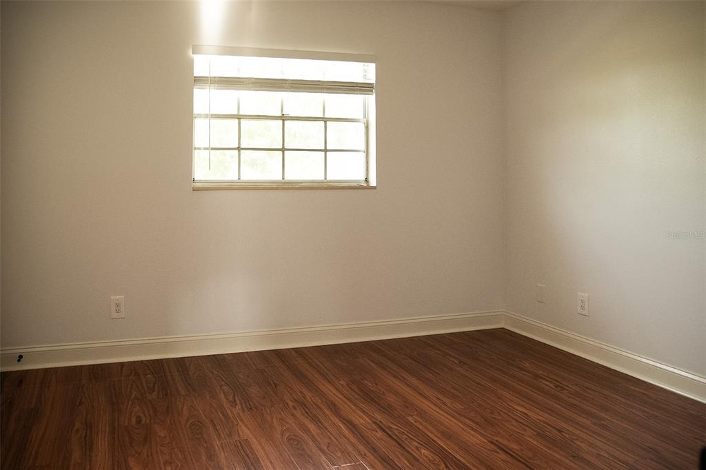 A kitchen features white cabinets, granite countertops, a stainless steel range hood, and white appliances — 120 S CHURCH AVENUE UNIT 207, TAMPA, FL