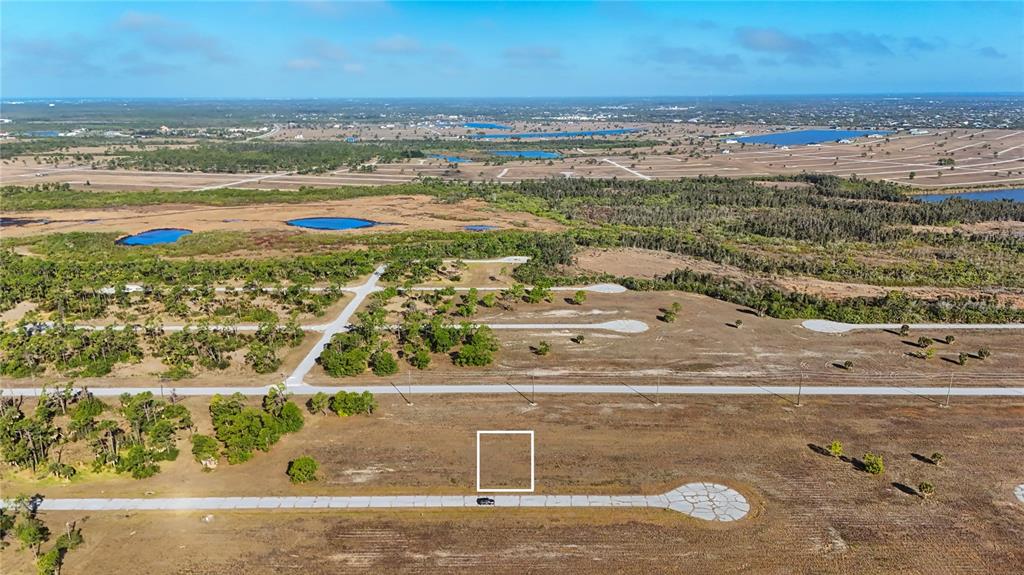 An aerial view shows a vacant residential lot outlined in white along a paved road — 14260 BLUEFISH COURT, PLACIDA, FL