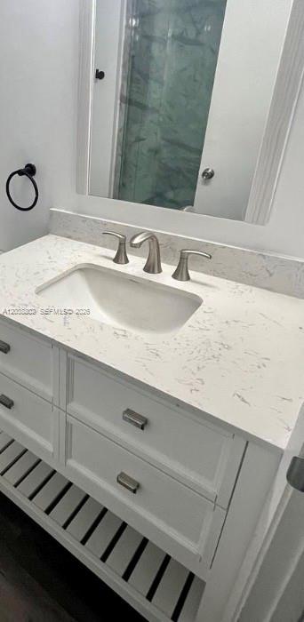 A bathroom vanity with a white marble countertop, undermount sink, and open slatted bottom shelf — 4501 W Mcnab Rd # 10, Pompano Beach FL 33069, POMPANO BEACH, FL