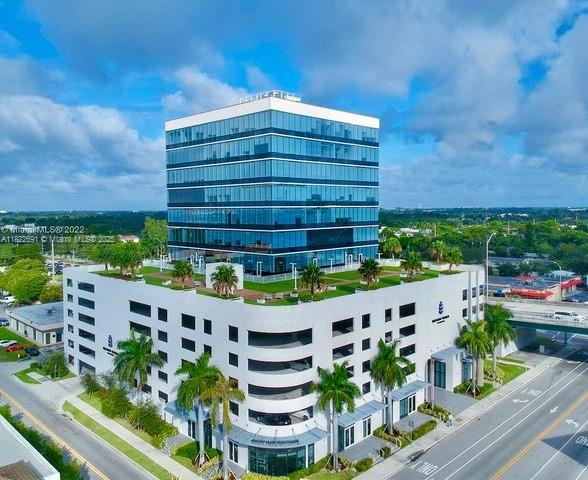 An aerial view of a modern glass office building atop a multi-level parking garage — 20200 W Dixie Hwy # 603, Miami FL 33180, MIAMI, FL
