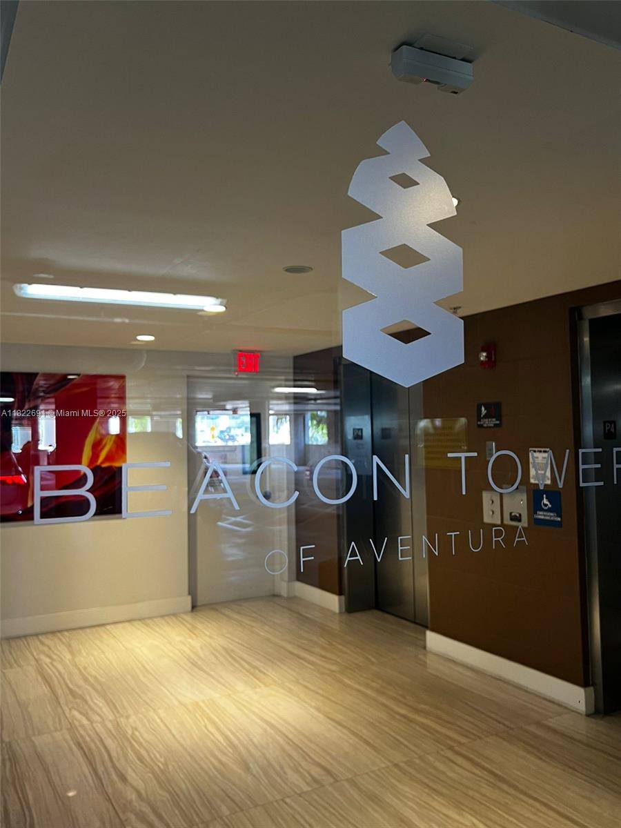 The interior lobby features a glass door with the Beacon Tower of Aventura logo — 20200 W Dixie Hwy # 603, Miami FL 33180, MIAMI, FL