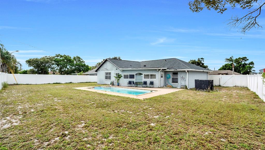 The backyard features a rectangular swimming pool, a patio area, and a white vinyl fence — 1160 MANITOBA STREET, DELTONA, FL