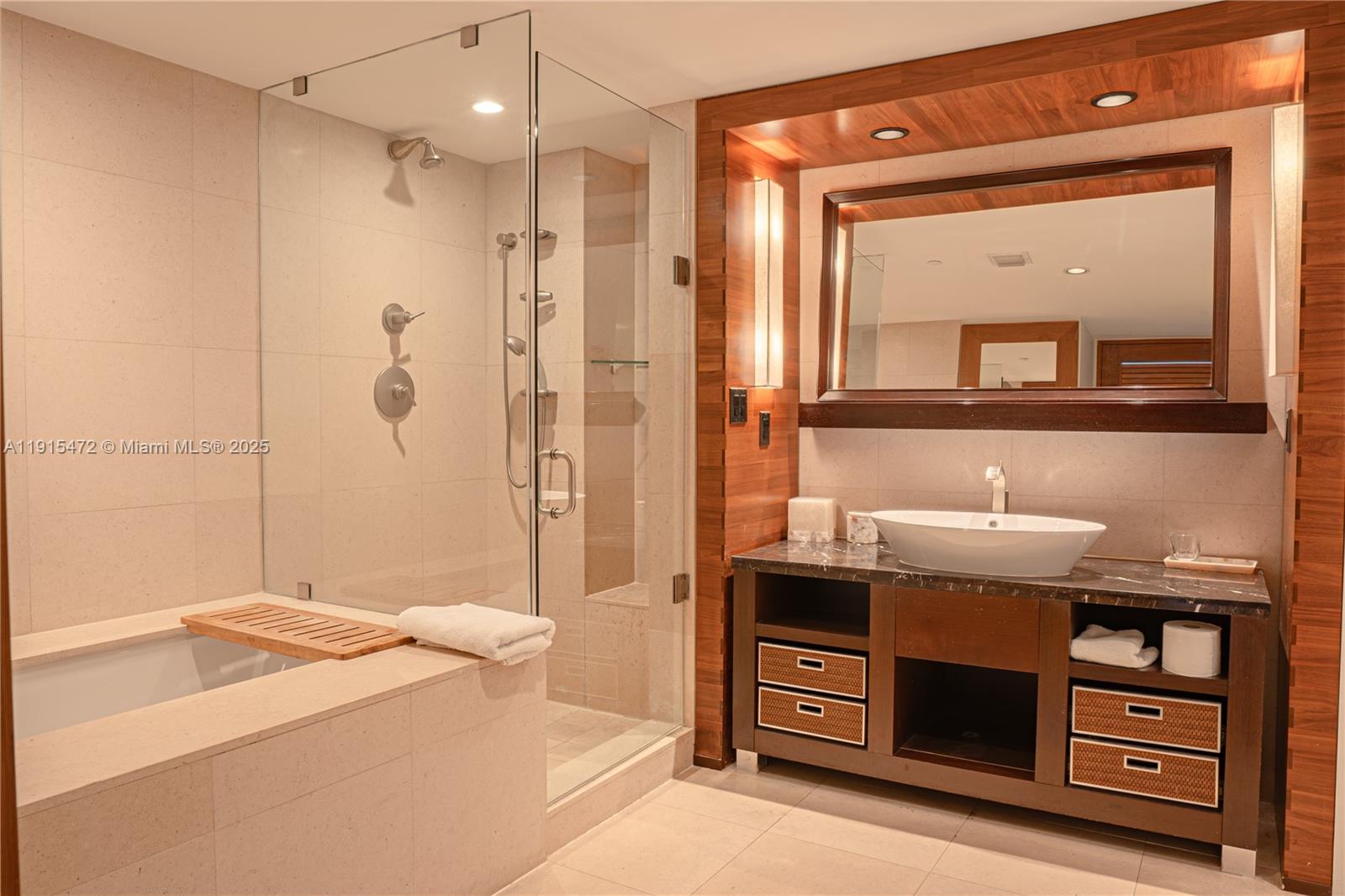 A modern bathroom features a glass-enclosed shower, a soaking tub, and a wooden vanity — 6801 Collins Ave # 1002, Miami Beach FL 33141, MIAMI BEACH, FL