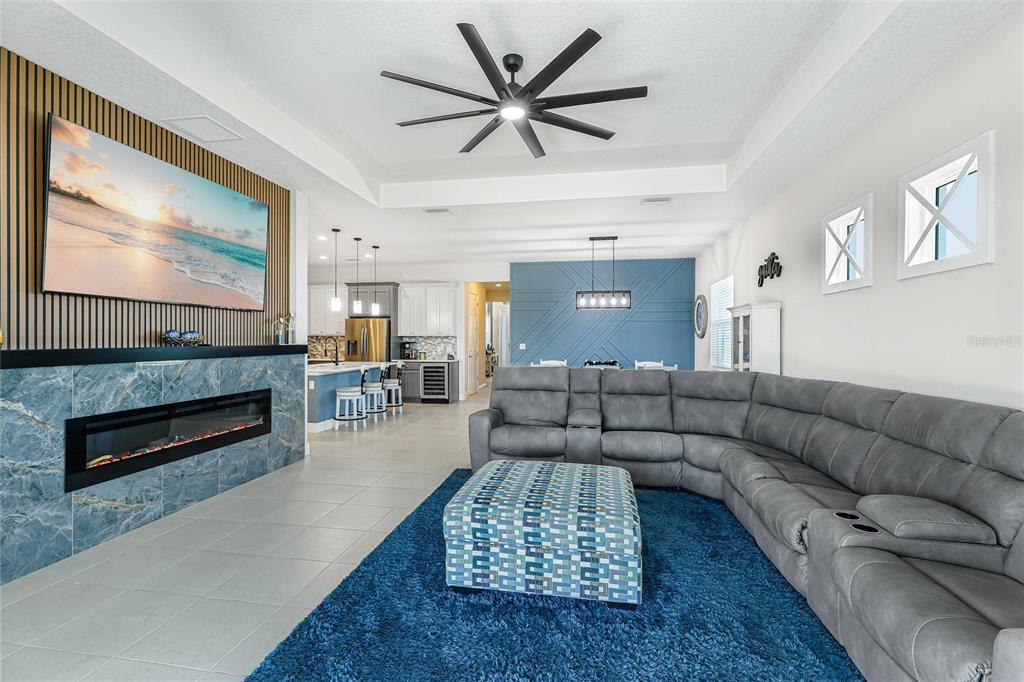 A living room features a blue stone fireplace, a gray sectional, and an open kitchen — 4316 SEA MARSH PLACE, PARRISH, FL