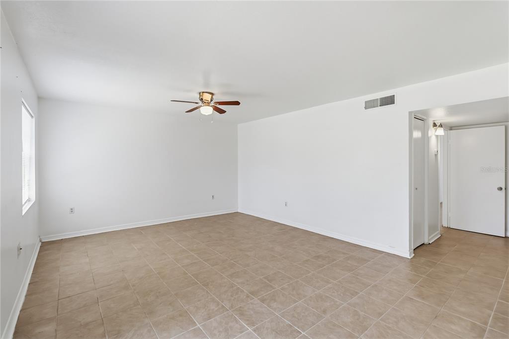 An empty room with white walls, a ceiling fan, and light-colored tile flooring — 2569 N ALAFAYA TRAIL UNIT 133, ORLANDO, FL