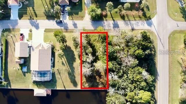 An aerial view shows a vacant, wooded residential lot outlined in red next to a house — 5 COLONIA COURT, PALM COAST, FL