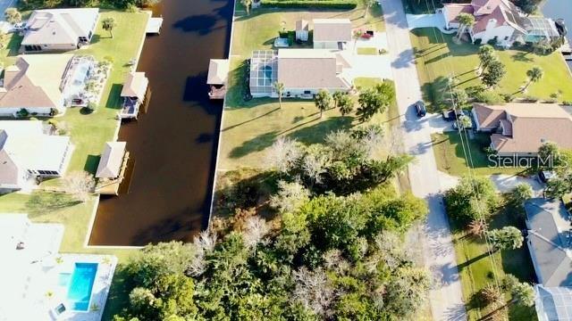 An aerial view shows a canal-front residential lot surrounded by houses and lush vegetation — 5 COLONIA COURT, PALM COAST, FL