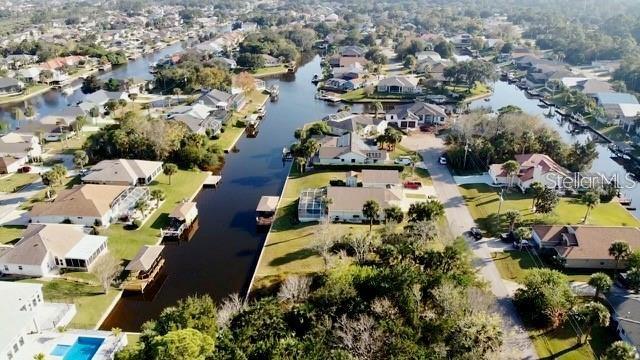 An aerial view shows residential houses along a canal in a suburban neighborhood — 5 COLONIA COURT, PALM COAST, FL