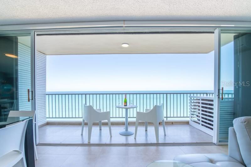 A modern kitchen with a white marble island overlooks a balcony and the ocean — 4745 ISLA VERDE AVENUE UNIT 17G, CAROLINA, PR
