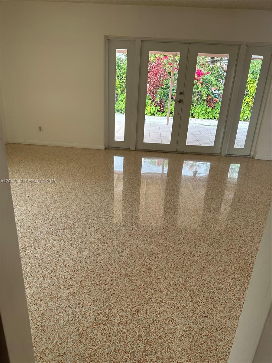 A room with light-colored walls and a polished terrazzo floor features glass double doors — 7931 SW 13th Ter # 7931, Miami FL 33144, MIAMI, FL