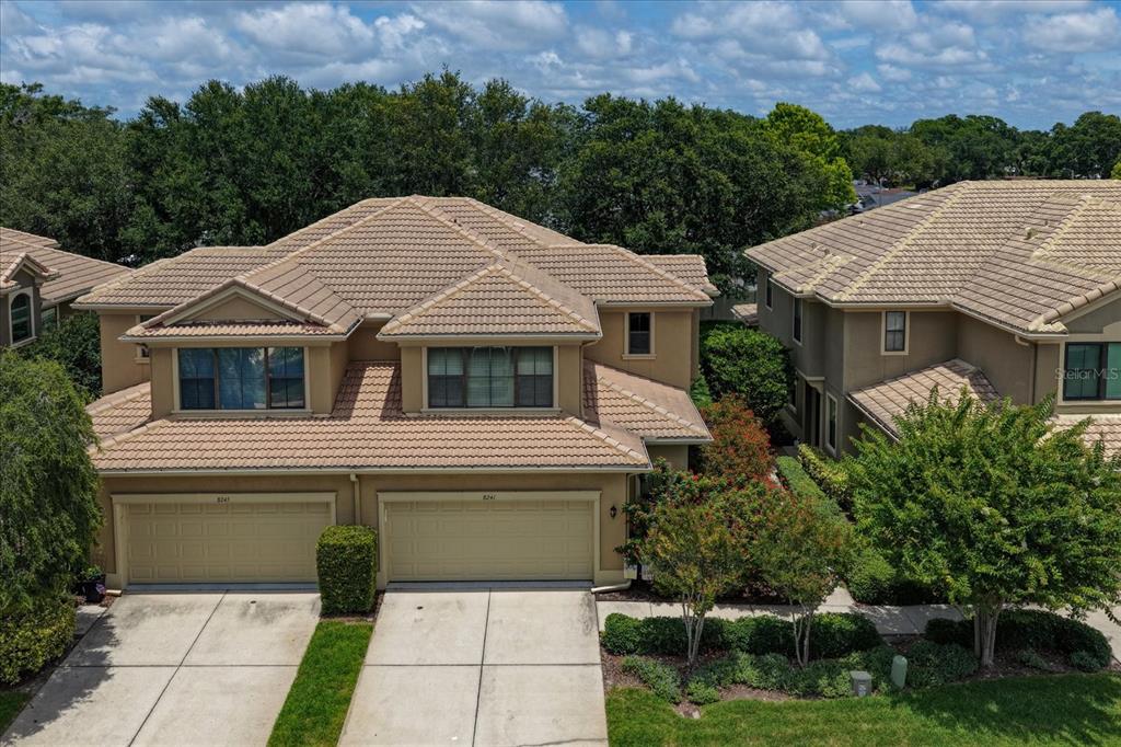 An aerial view of two attached townhomes with tan stucco walls and tiled roofs — 8241 ACADIAN LANE, SEMINOLE, FL