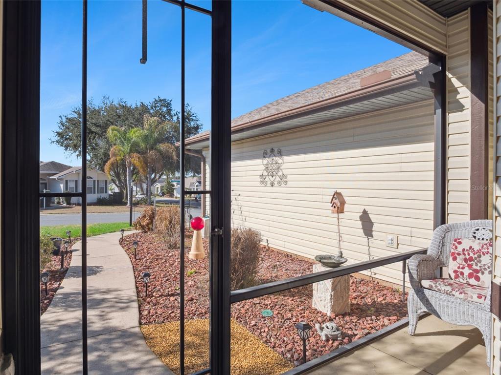 A view from a screened-in porch looking out at a sidewalk and a neighboring house — 4921 GLEN COE STREET, LEESBURG, FL