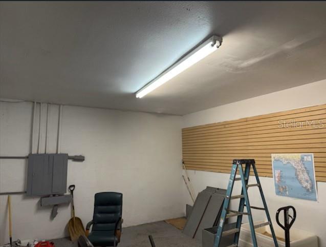 A garage interior features a fluorescent light, a slat wall, a ladder, and a chair — 2525 N BETHLEHEM ROAD UNIT A, PLANT CITY, FL