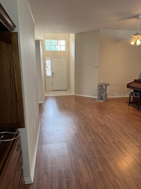 An interior view shows a living area with wood-look flooring, a front door, and a piano — 1102 STILLWATER DRIVE, DELAND, FL