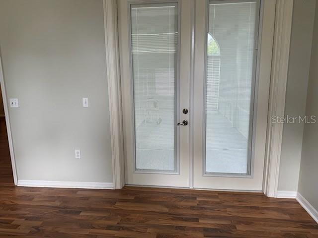 A room with wood-look flooring and double glass doors leading to a screened-in porch — 1102 STILLWATER DRIVE, DELAND, FL