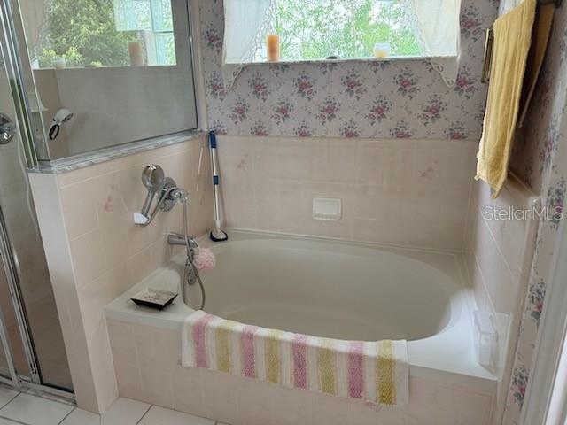 A bathroom features a built-in soaking tub with floral wallpaper and a shower stall — 1102 STILLWATER DRIVE, DELAND, FL