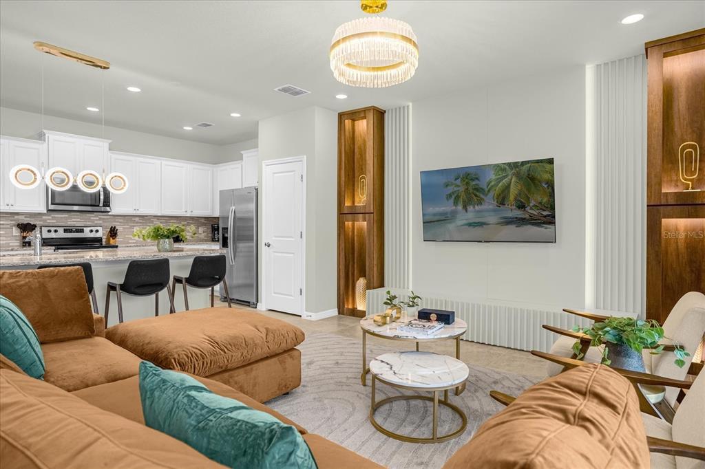 A living room with a brown sectional sofa, two nesting coffee tables, and an open kitchen — 4310 LANA AVENUE, DAVENPORT, FL