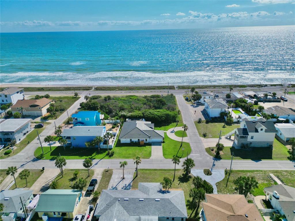 An aerial view of a coastal neighborhood featuring houses, palm trees, and the ocean — 112 S 11TH STREET, FLAGLER BEACH, FL