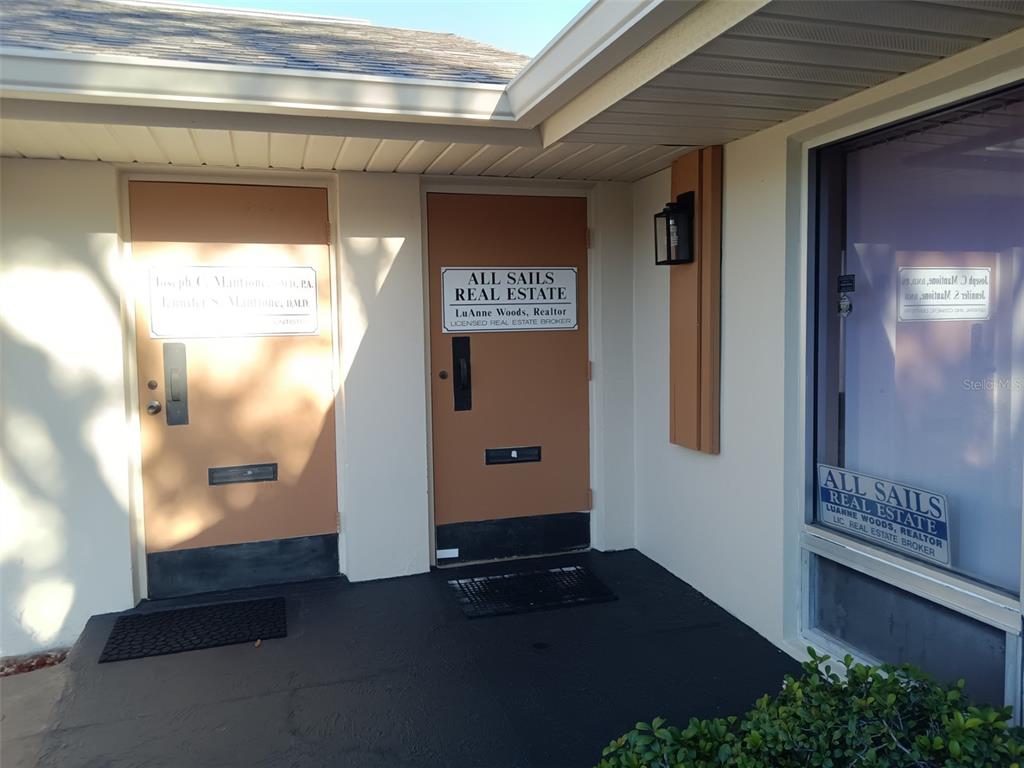 The exterior entrance features two brown doors with business signage and a large window — 6967 SUNSET DRIVE S, ST PETERSBURG, FL