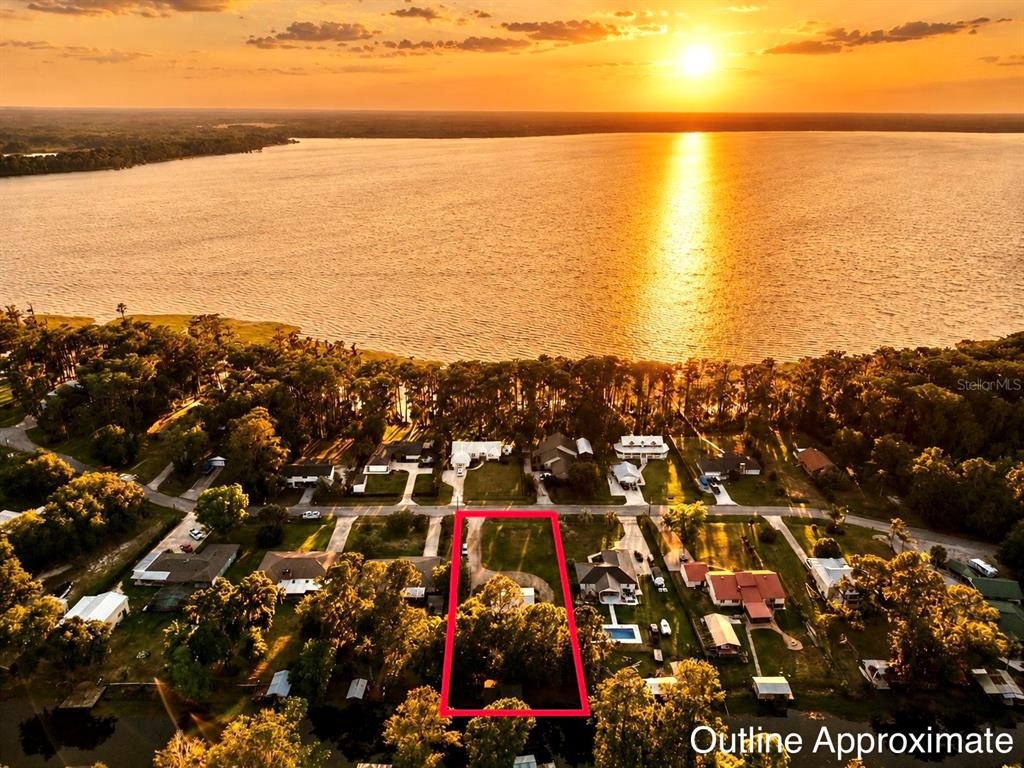 An aerial view shows a residential lot outlined in red near a large lake — 529 SE 5TH AVENUE, MELROSE, FL