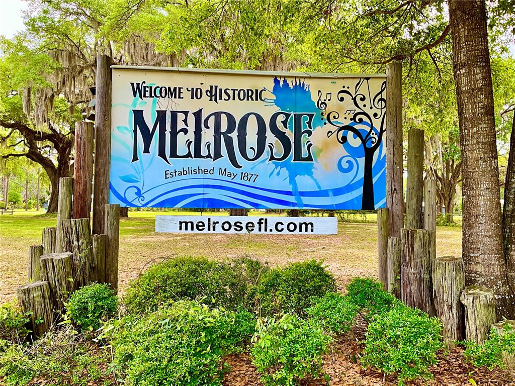 A sign welcoming visitors to historic Melrose, Florida, stands in a grassy, tree-filled area — 529 SE 5TH AVENUE, MELROSE, FL
