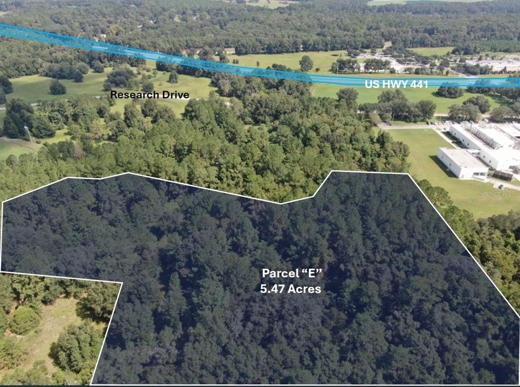 An aerial view shows a wooded 5.47-acre parcel of land near a highway — TECHNOLOGY AVENUE, ALACHUA, FL
