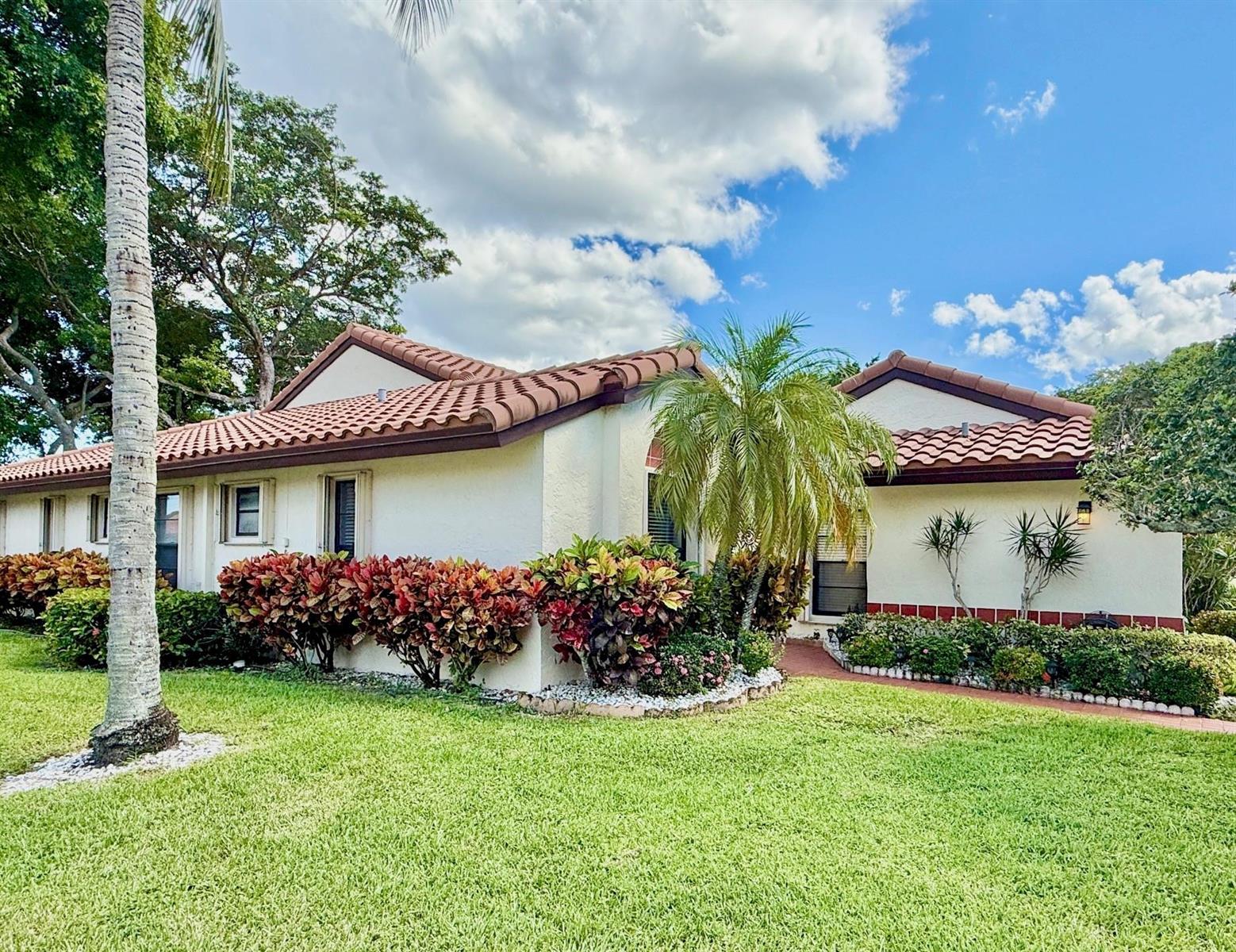 A single-story house with a terracotta tile roof, white stucco walls, and tropical landscaping — 5462 Palm Springs Lane # A, Boynton Beach FL 33437, BOYNTON BEACH, FL