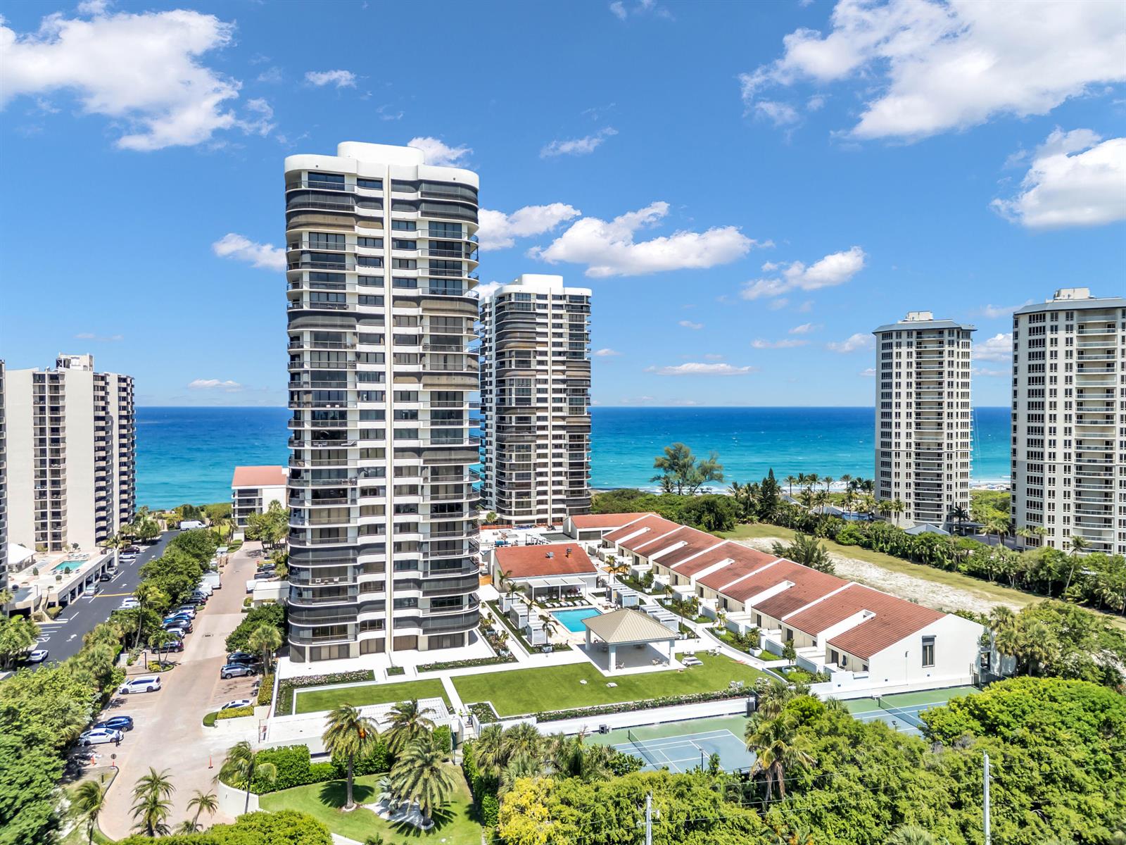 An aerial view shows several high-rise apartment buildings near a beach with a swimming pool — 4100 N Ocean Drive # 1101, West Palm Beach FL 33404, WEST PALM BEACH, FL