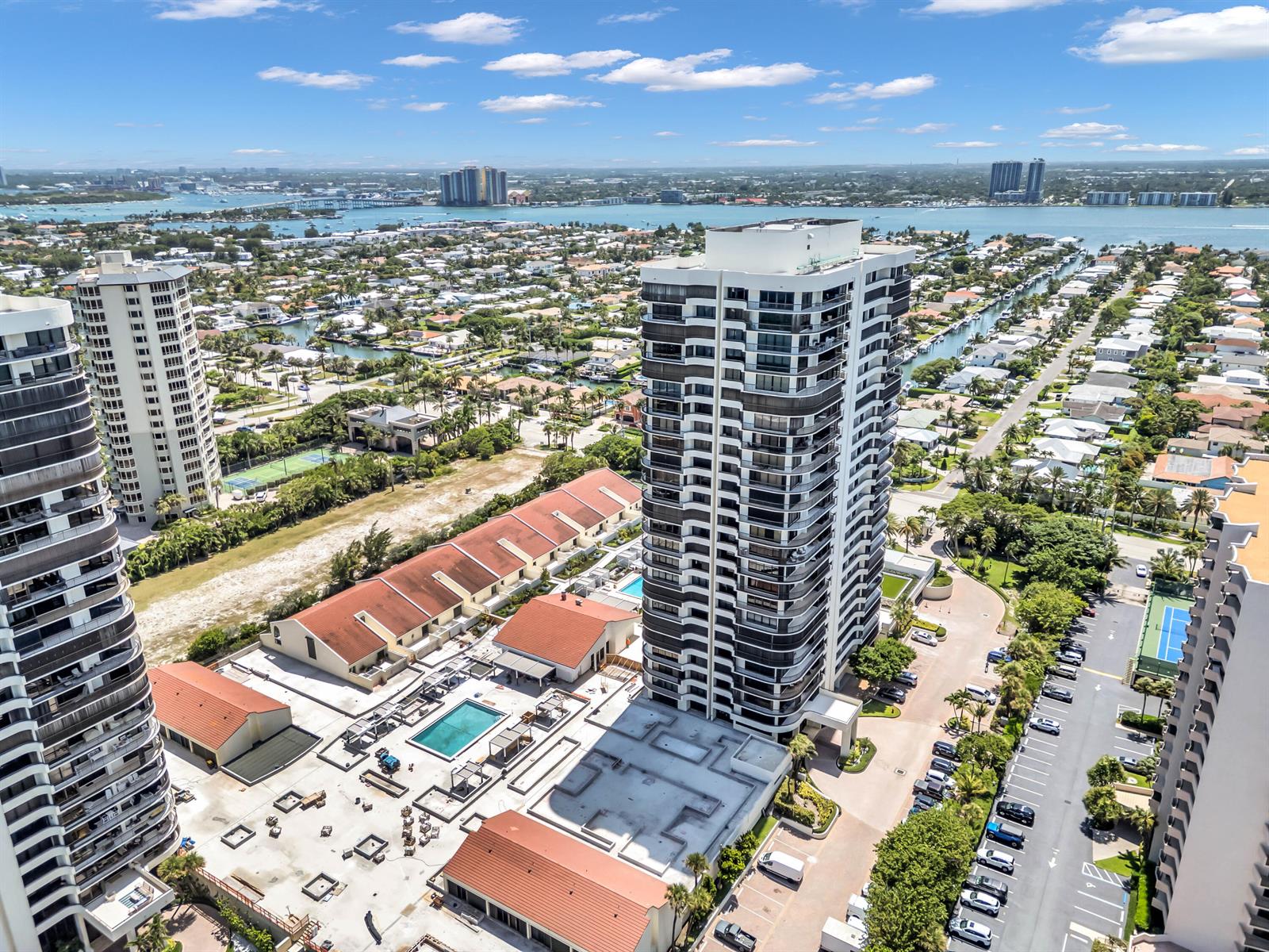 An aerial view shows high-rise apartment buildings, a swimming pool, and surrounding residential properties — 4100 N Ocean Drive # 1101, West Palm Beach FL 33404, WEST PALM BEACH, FL