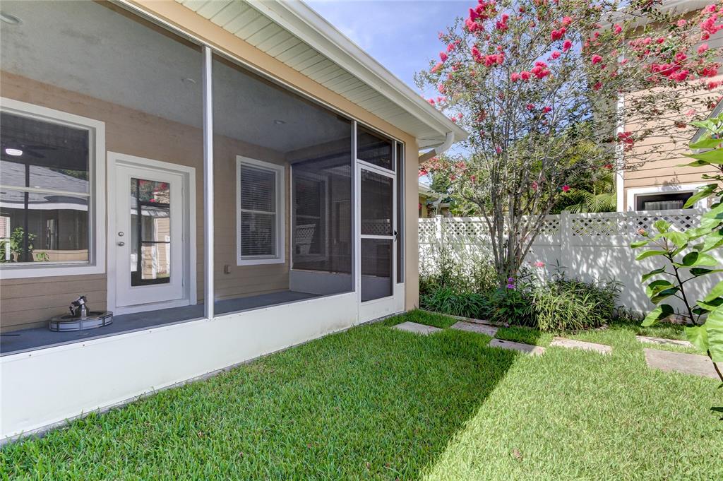 An empty room with wood-look flooring, white walls, a ceiling fan, and a staircase — 14606 BOURNEMOUTH ROAD, TAMPA, FL