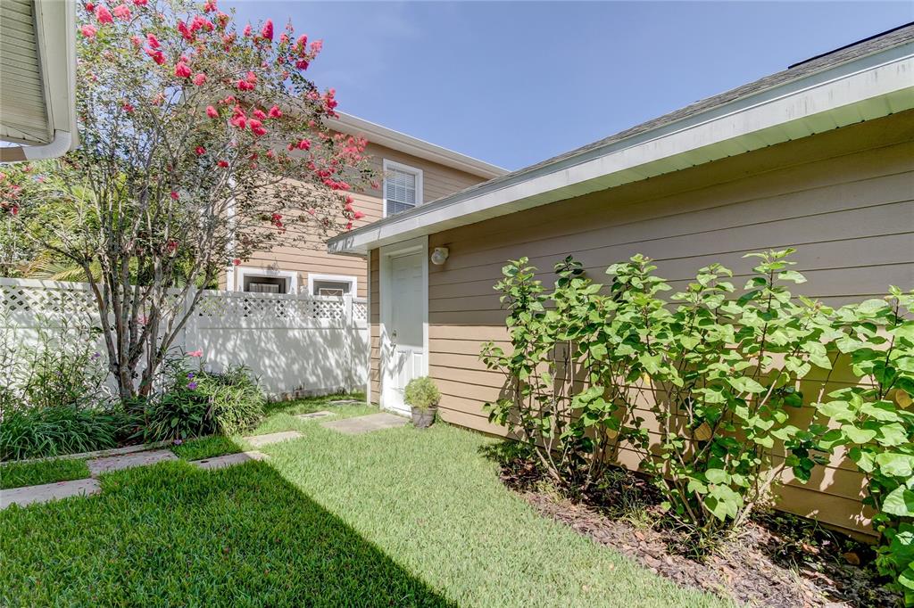 A room with light gray walls, wood-look flooring, a window with shutters, and a staircase — 14606 BOURNEMOUTH ROAD, TAMPA, FL