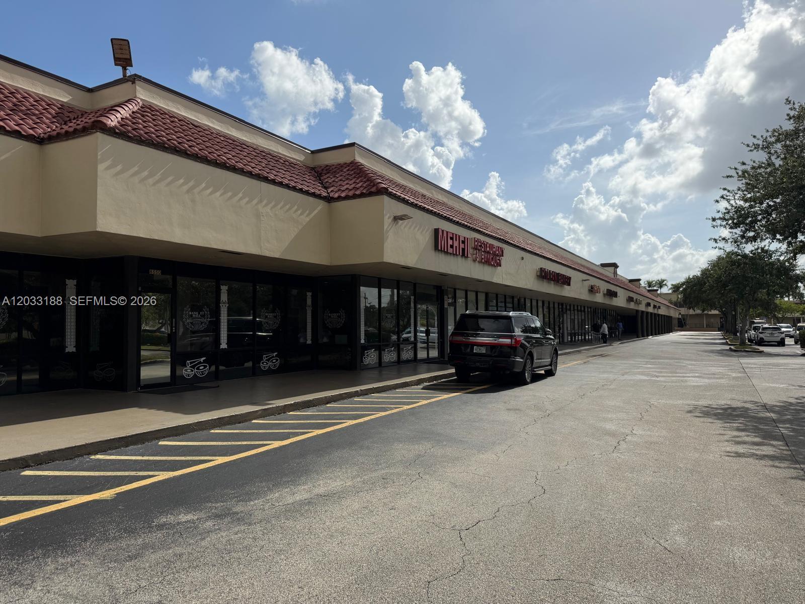 A single-story commercial strip mall features a tan facade, red tile roof, and parking lot — 8618 NW 44th st, Sunrise FL 33351, SUNRISE, FL