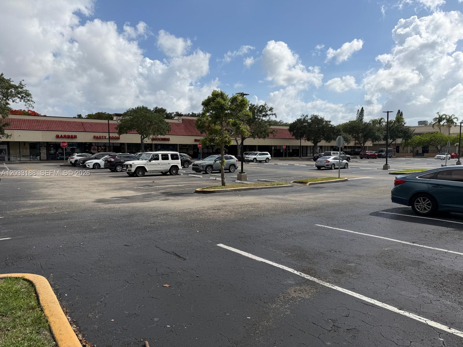 A parking lot in front of a single-story commercial strip mall under a cloudy sky — 8618 NW 44th st, Sunrise FL 33351, SUNRISE, FL
