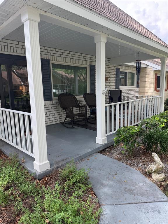 A covered front porch features white columns, a gray floor, and a white railing — 8591 SW 93RD PLACE UNIT B, OCALA, FL