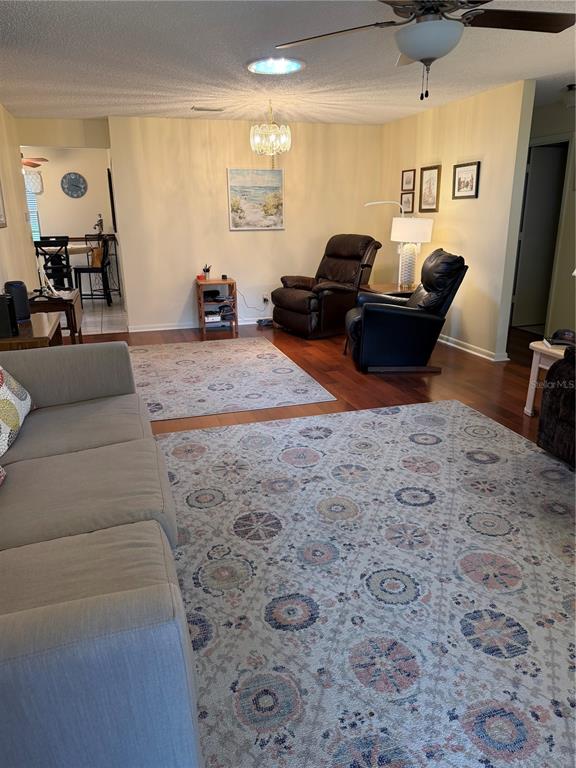 A living room features two area rugs, a sofa, two recliners, and hardwood flooring — 8591 SW 93RD PLACE UNIT B, OCALA, FL
