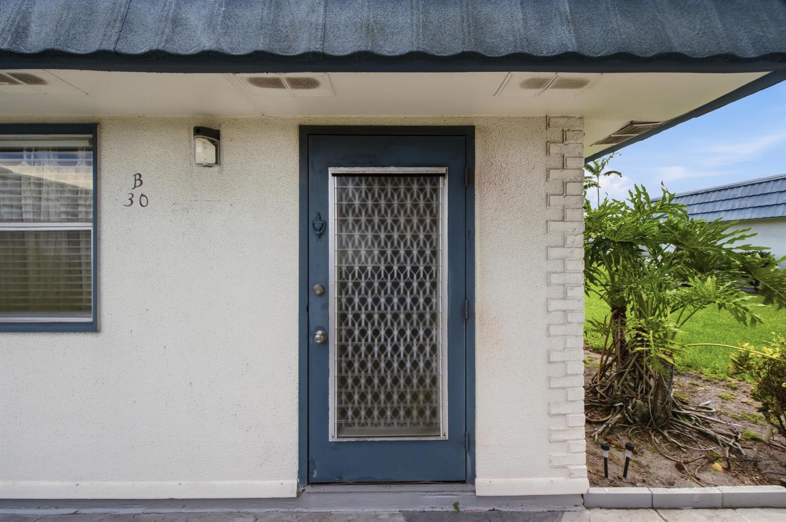The exterior of a unit features a blue door with a patterned glass insert — 30 Waterford B, Delray Beach FL 33446, DELRAY BEACH, FL