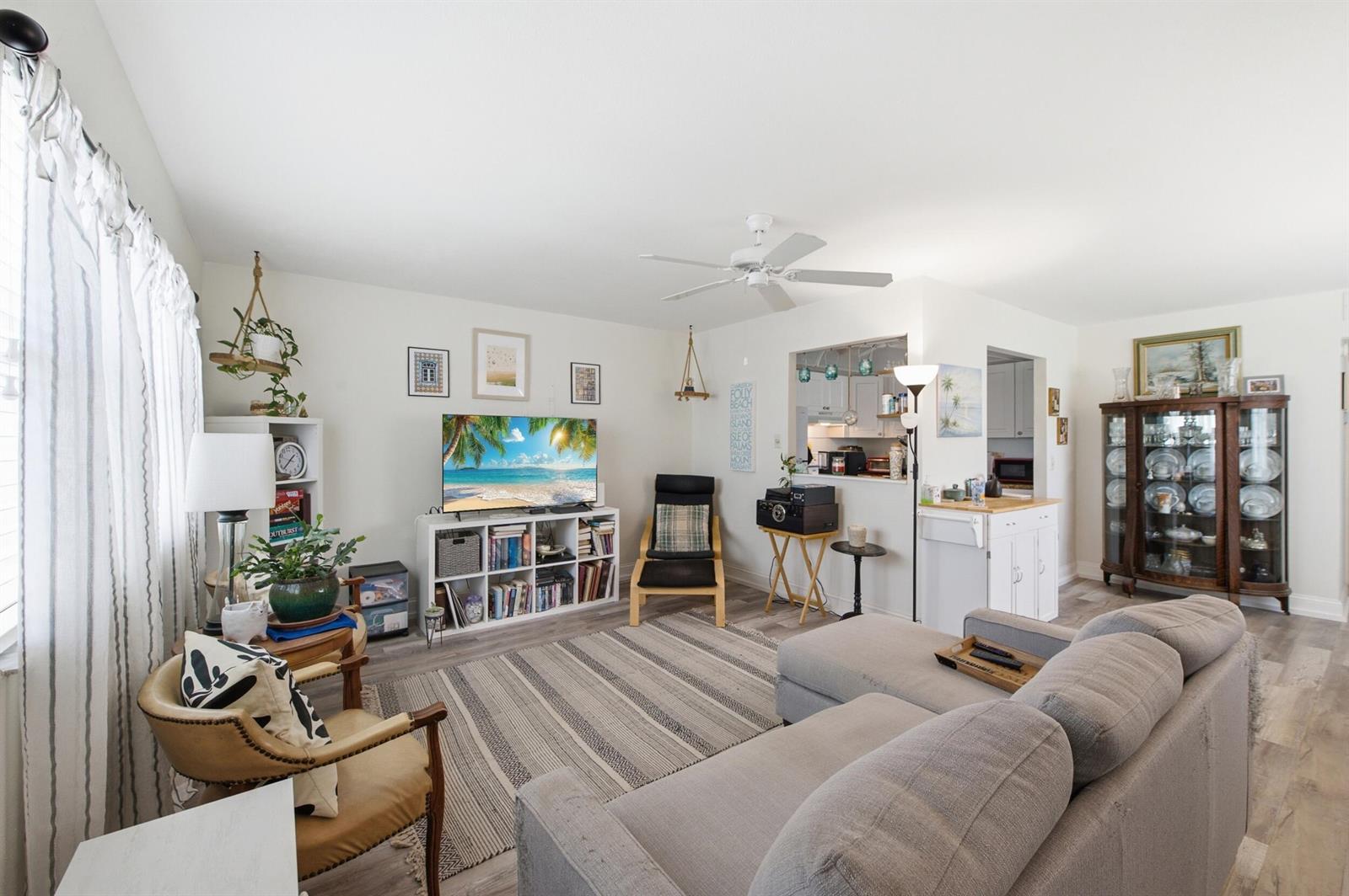 A living room features a grey sectional sofa, a television on a bookshelf, and a dining hutch — 30 Waterford B, Delray Beach FL 33446, DELRAY BEACH, FL