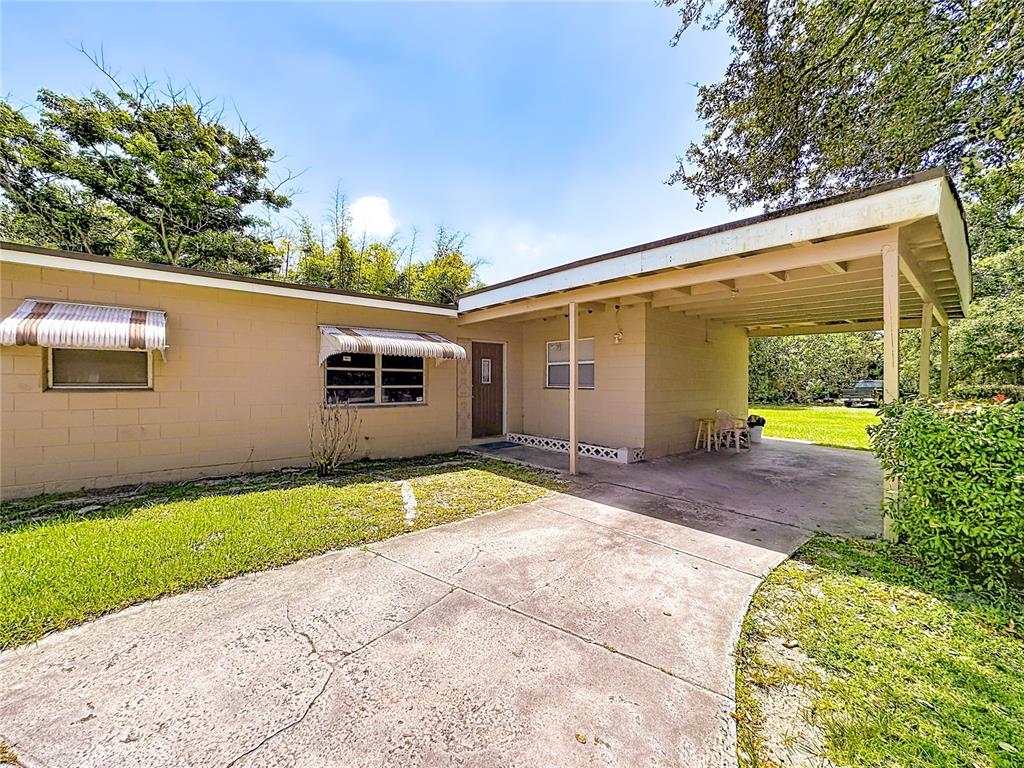 A single-story house with a concrete block exterior, a carport, and striped window awnings — 202 N 39TH STREET, FORT PIERCE, FL