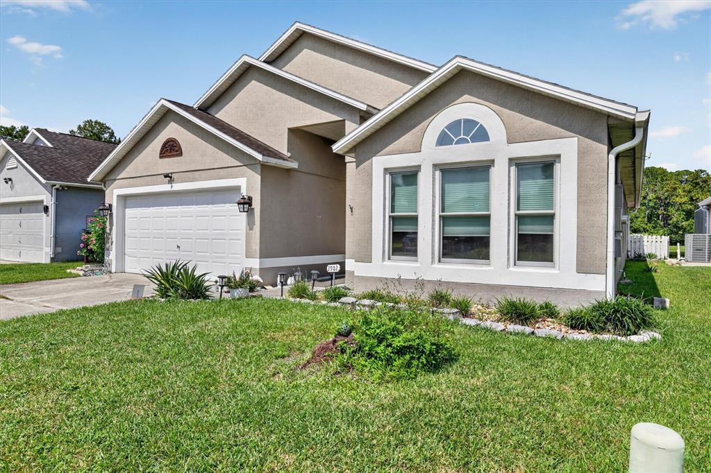 A beige single-story house with a two-car garage and a front-facing triple window — 2902 AFTON CIRCLE, ORLANDO, FL