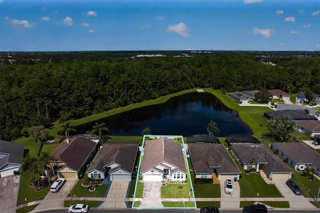 An aerial view shows a suburban house with a fenced backyard overlooking a small lake — 2902 AFTON CIRCLE, ORLANDO, FL