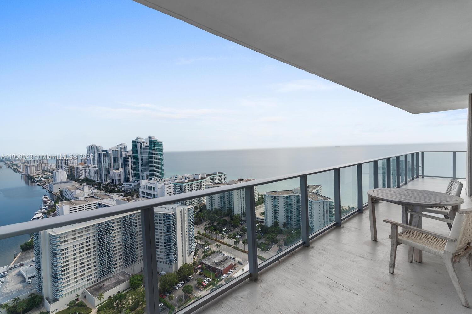 A high-rise balcony features a glass railing, outdoor furniture, and a panoramic ocean view — 4010 S Ocean Dr # R2501, Hollywood FL 33019, HOLLYWOOD, FL