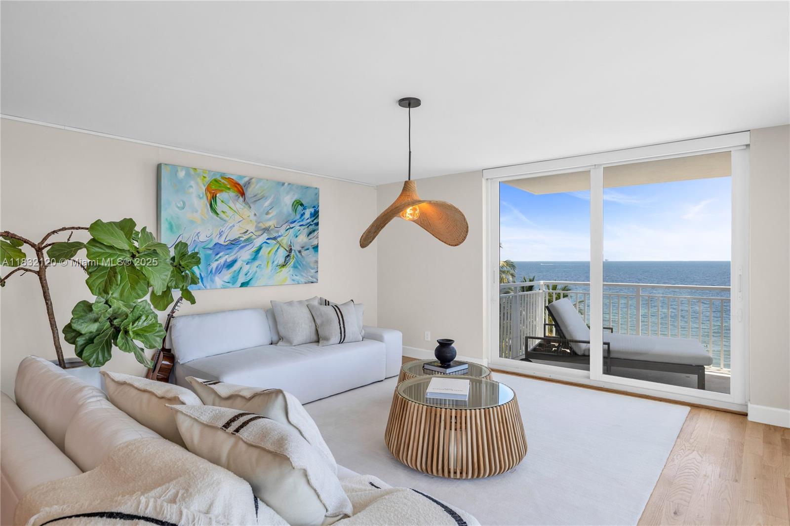 A living room features a white sofa, two round coffee tables, and a balcony overlooking water — 615 Ocean Dr # 6A, Key Biscayne FL 33149, KEY BISCAYNE, FL